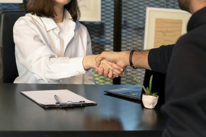 A handshake across a desk
