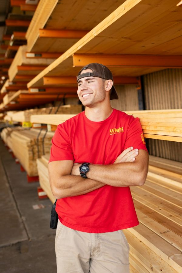 A tradesman in a red work shirt with his arms crossed