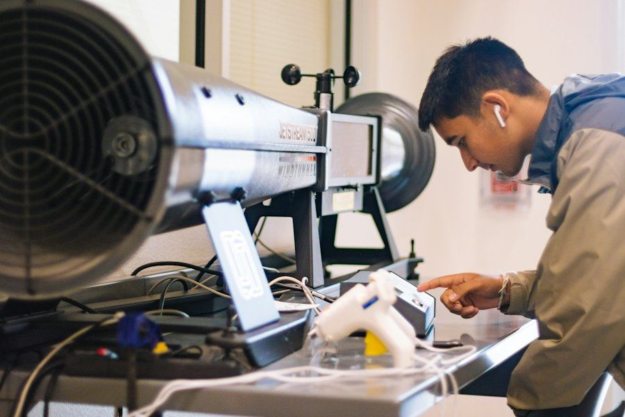 A technician checking a reading on test equipment at a workbench
